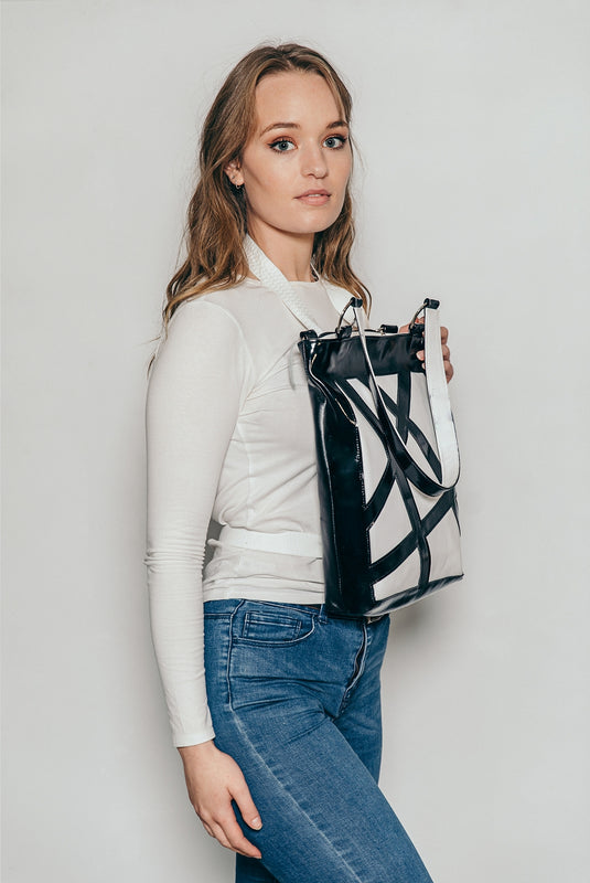 A lady wearing white shirt while holding her bulletproof bag